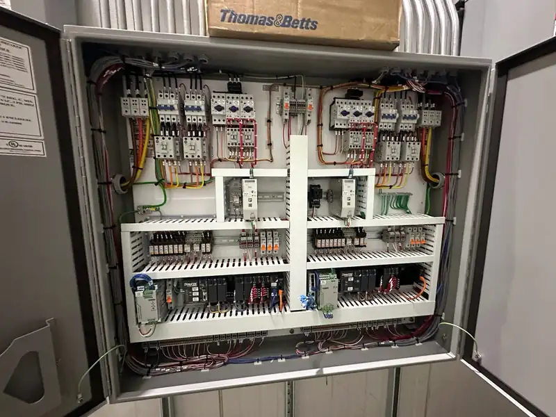 Industrial refrigeration engine room with screw compressors and control panels